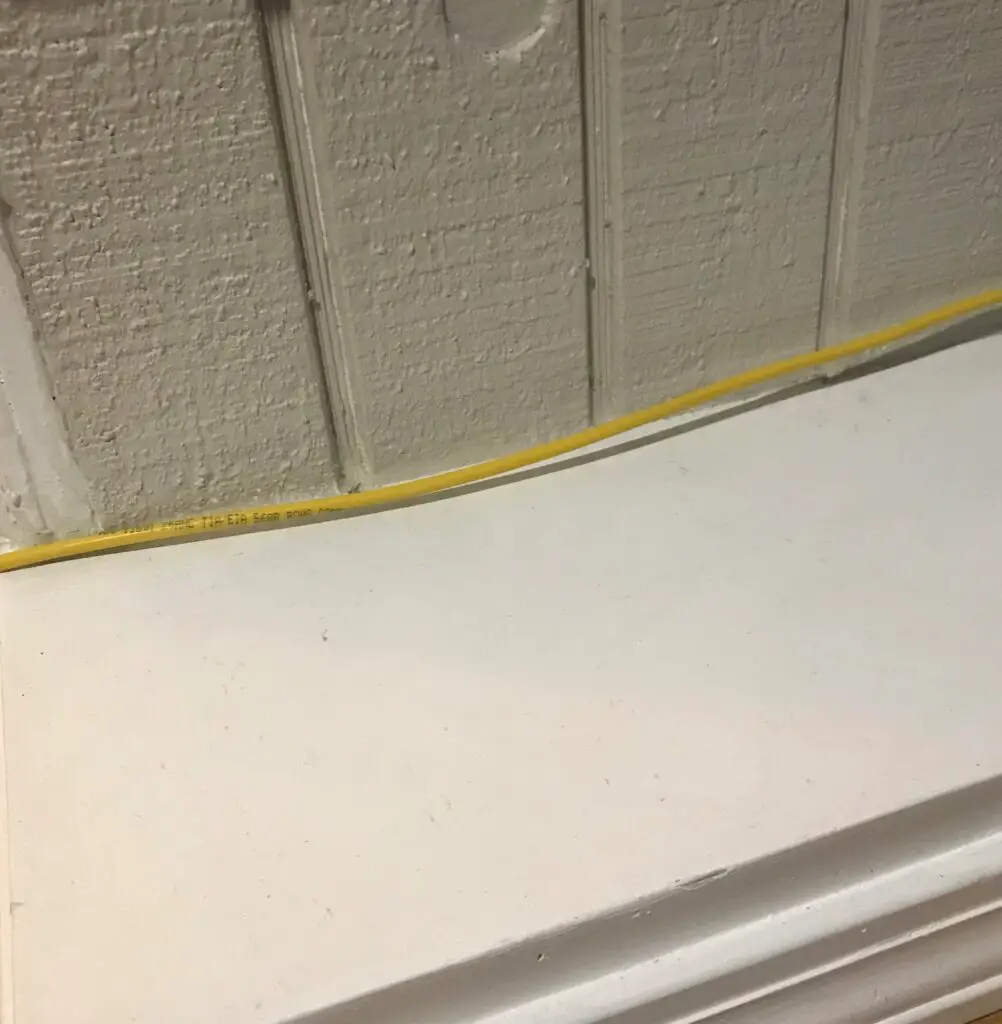 Yellow cable against gray wall