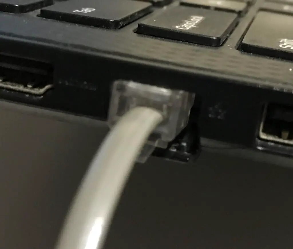 Phone cable plugged into laptop ethernet cable jack